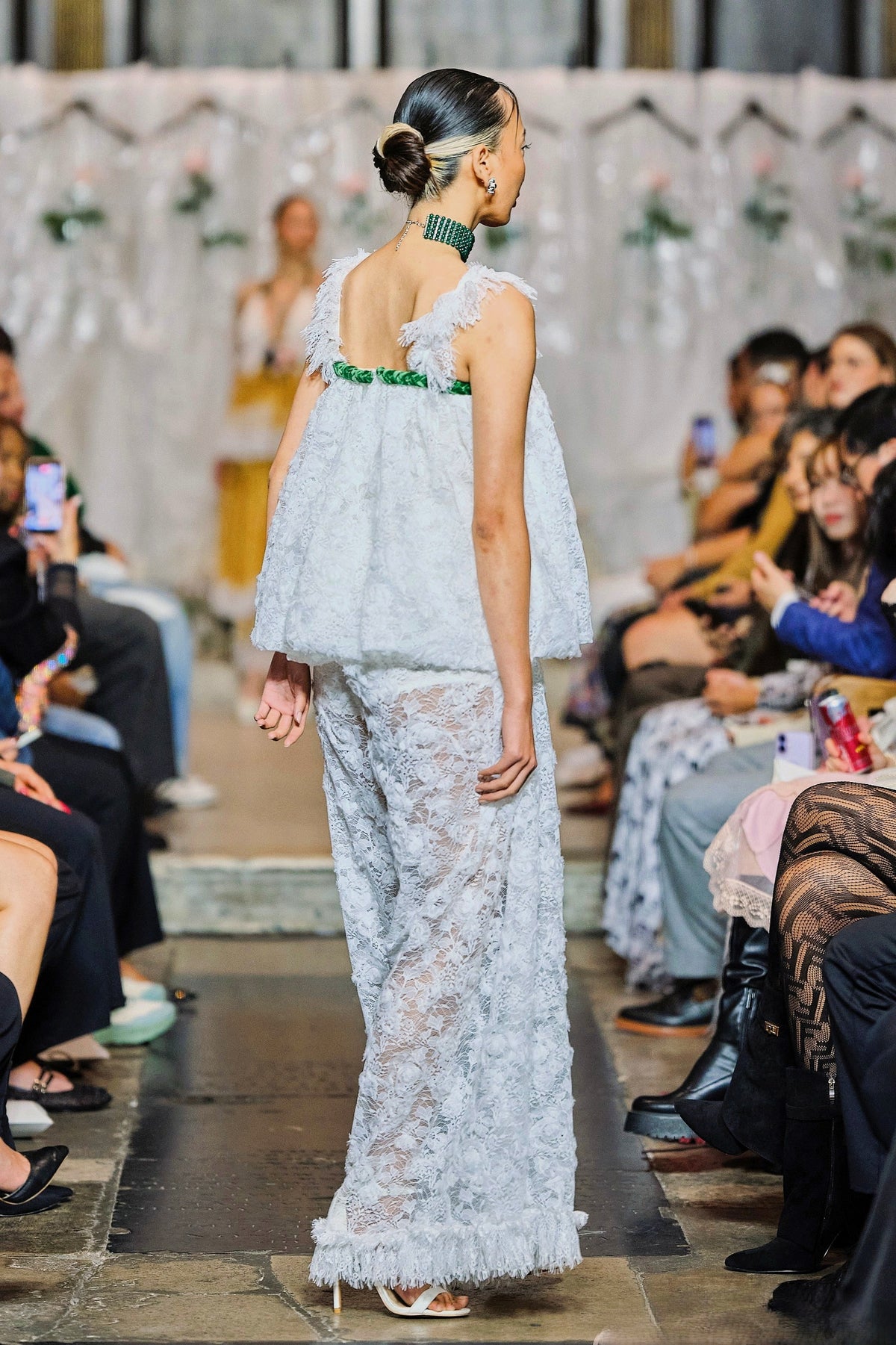 Long lace jumpsuit with relaxed bodice, floral accents and wide-leg trousers.