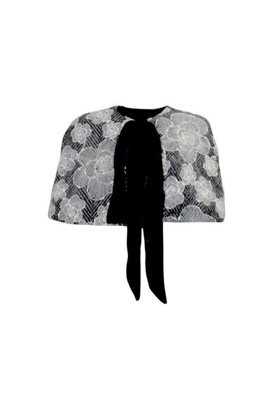 Floral patterned cape with a black tie on a white background