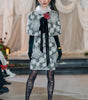 Model walking on a fashion runway wearing a patterned outfit with a floral accessory.