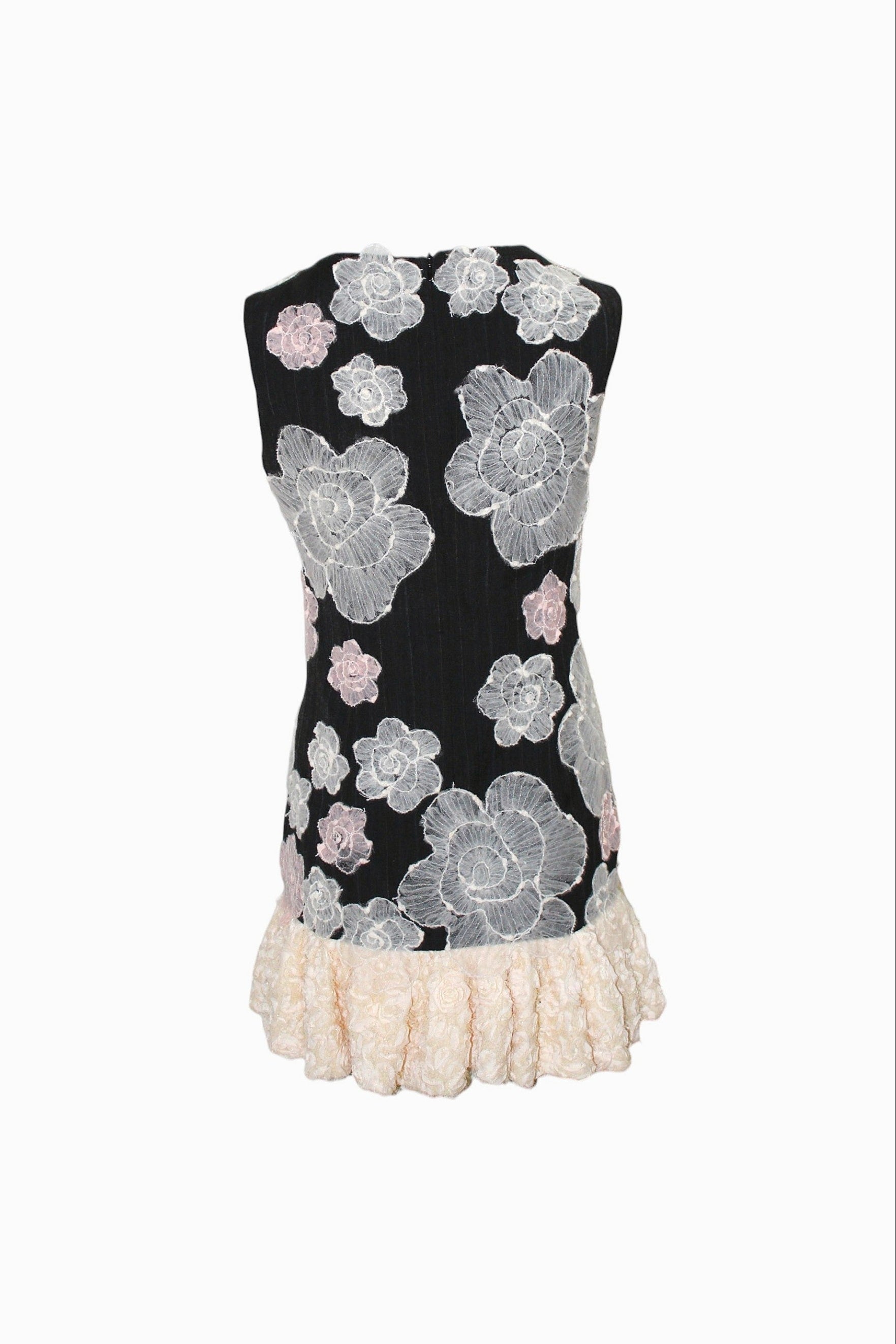Black strapless dress with floral lace design and white ruffle hem on a white background