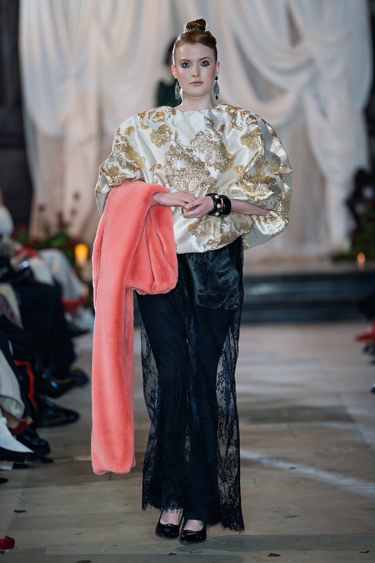 Gold textured jacquard blouse with relaxed silhouette and soft volume styled with sheer lace trousers on runway