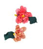 Two floral hair clips with pink and green colors on a white background