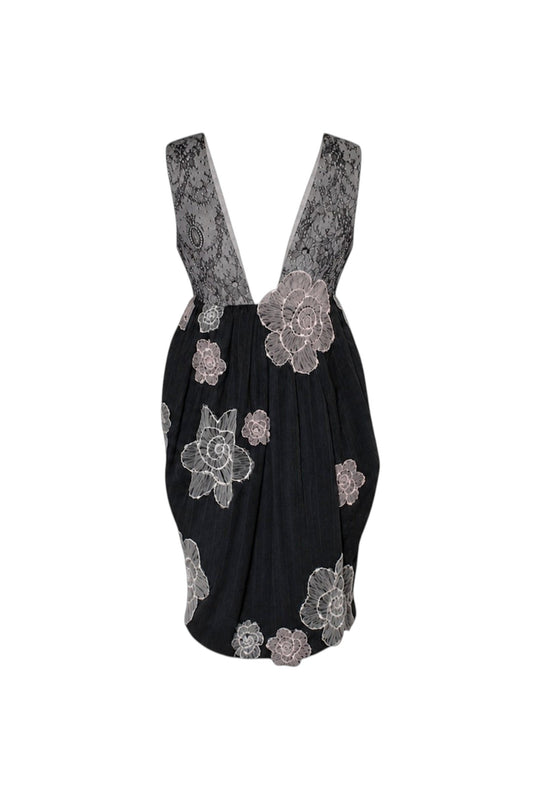 Black dress with floral lace details on a white background