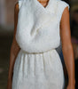 White textured dress worn by a model with a blurred background