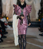 Model wearing a pink sequin dress with ruffled details on a runway.