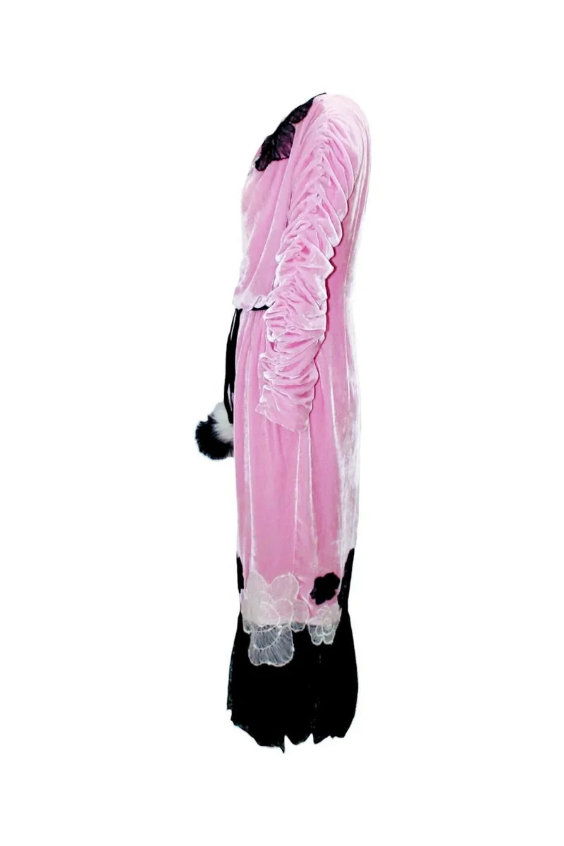 Pink and black costume with ruffled details on a white background