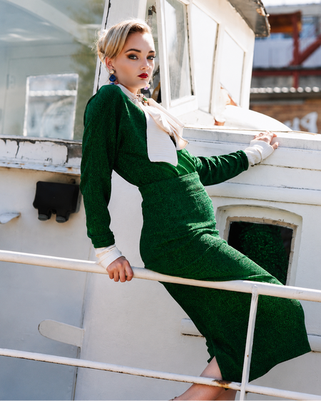 Woman in a green dress standing on a boat
