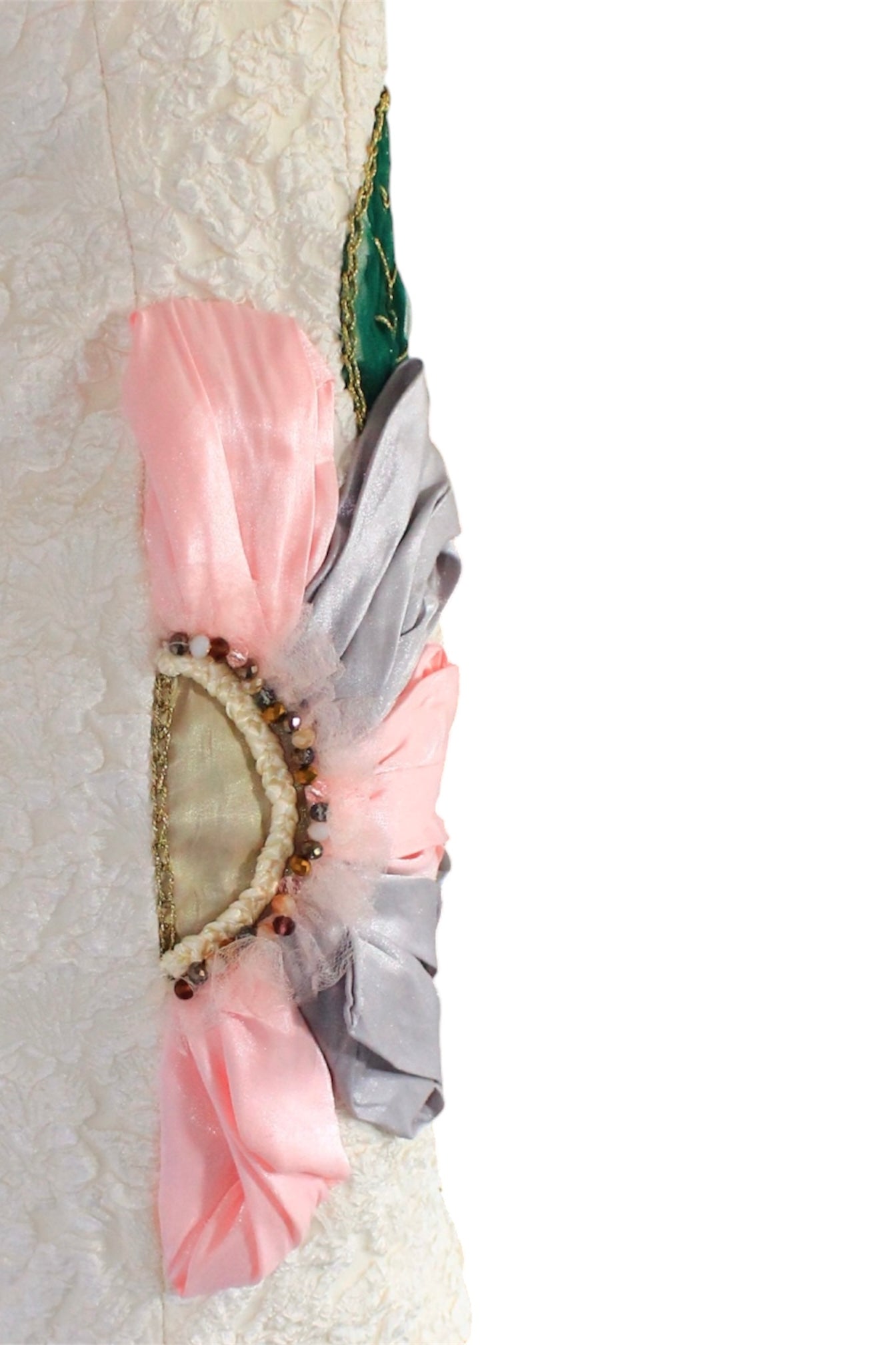Decorative arm sleeve with pink and gray fabric and embellishments on a white background